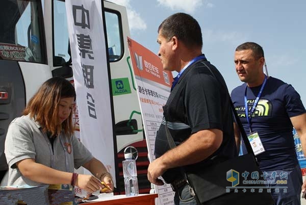 在亞歐博覽會(huì)室外嘉年華展區(qū)，聯(lián)合卡車營(yíng)銷服務(wù)人員正在接待兩名俄羅斯客戶